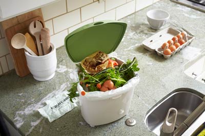 Colleting food scraps in Compost bin on counter while cooking