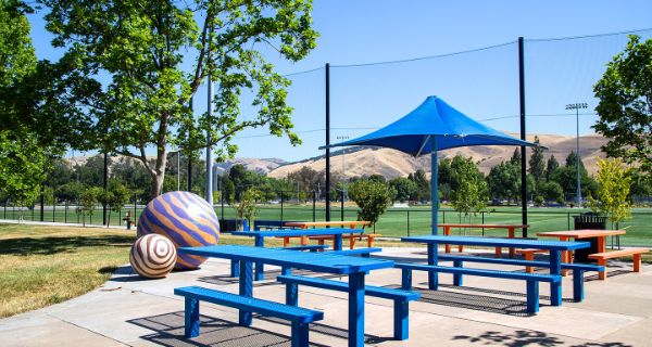 Picnic area in playground with park in background