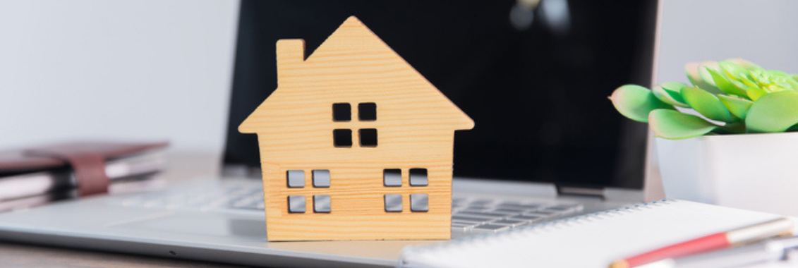 Wooden house on top of laptop