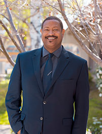 ITS Director Sandy Taylor standing in front of trees