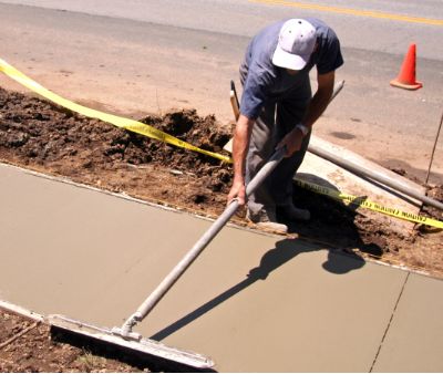 Contractor smoothing new sidewalk