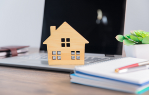 Laptop and wooden house on desk