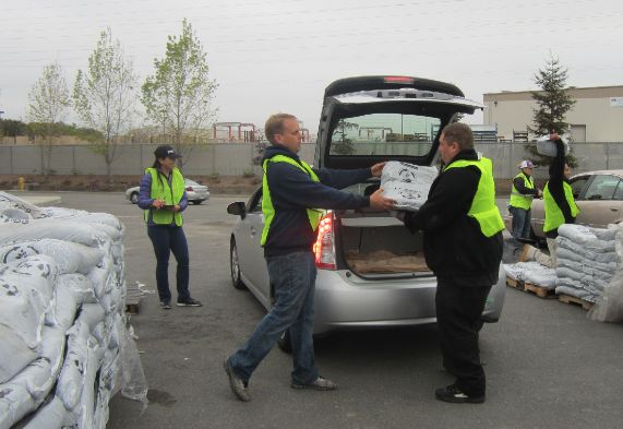 Compost Giveaway Day, workers load bags in car