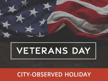 US flag. Veterans Day and City-Observed Holiday in text