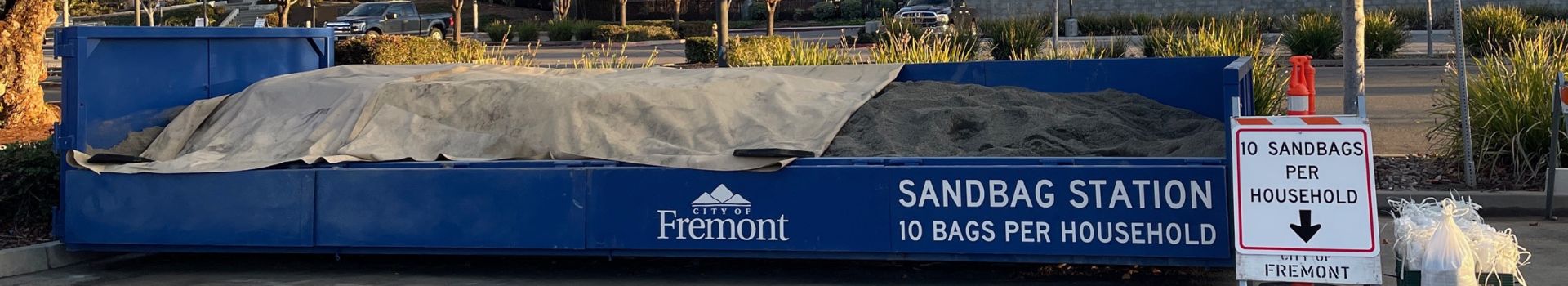 Sandbags Station with sand in a roll-off bin and bags