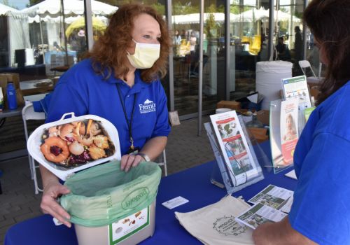 Environmental services staff explains how to compost kitchen scraps to Earth Day attendee