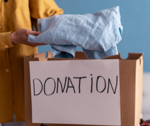 Person placing a shirt in a donation box